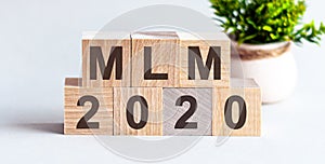 MLM 2020 word written on wood block. Faqs text on table, concept