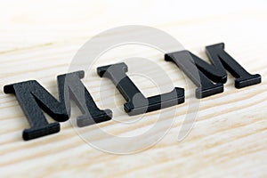 MLM (or Multi-Level Marketing) letters on wood background