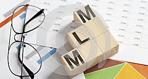 MLM Multi-Level Marketing written on a wooden cubes