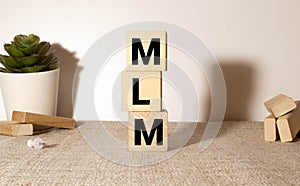 MLM Multi-Level Marketing written on a wooden cubes