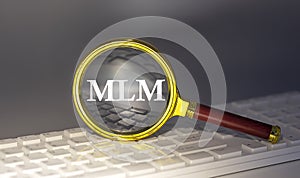 MLM text on magnifier on a keyboard, business concept