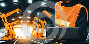 MLP Engineer use advanced robotic software to control industry robot arm in factory
