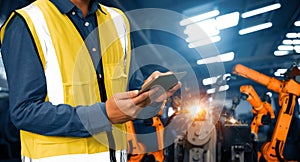 MLP Engineer use advanced robotic software to control industry robot arm in factory