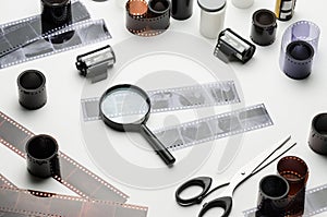 35mm films, magnifying glass and scissors on white background