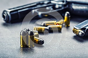 9 mm pistol gun and bullets strewn on the table photo