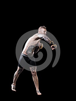 MMA fighter practising punching on black background
