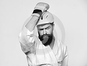 MMA sports concept. Man with beard in kimono and pink helmet on white