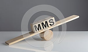 MMS - Multimedia Messaging Service on wooden cubes on a wooden balance , business concept