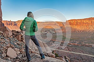 3/21/19 Moab, Utah.  Woman watching the moon rise and the sun set, after a long day of rock climbing.