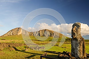 Moai located at Tongariki\'s entrance with Rano Raraku volcano at the background