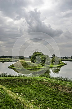 Moat island under a dramatic sky