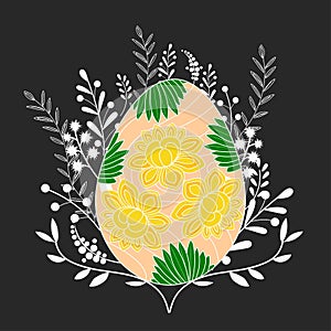 Bright Easter egg with floral decoration on the dark background with white branches.