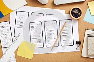 Mobile app wireframes over UX designer desk