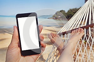 Mobile application for travels, phone in hand, beach photo