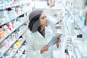 Mobile apps that have pharmacy management covered. Shot of a young woman using a digital tablet to do inventory in a