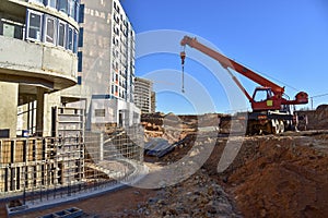 Mobile auto crane during pouring the formwork of the porch at the entrance of a residential building. Frame of reinforcement,