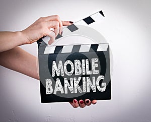 Mobile banking concept. Female hands holding movie clapper