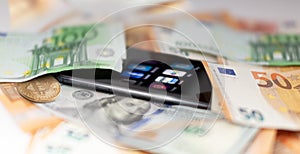 Mobile banking and finance concept: smartphone with applications, euro, US dollar banknotes, and bitcoin