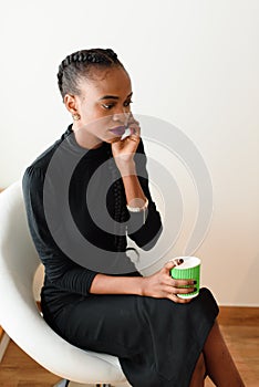 Mobile business woman in the office talking on her cell phone while holding disposable cup