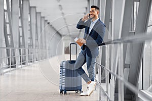 Mobile Call. Smiling Young Middle Eastern Businessman Talking On Cellphone In Airport