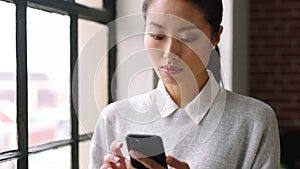 Mobile, communication and business with an asian woman typing a text message in her office at work. Mobile, networking