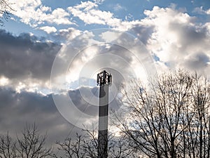 Mobile communications tower on a background of cloudy sky