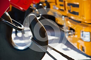 Mobile construction cranes with yellow telescopic arms and big tower cranes in sunny day