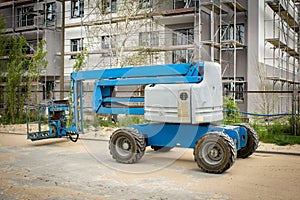 Mobile crane at construction site. Boom lift outdoors. Telescopic elevator for rent