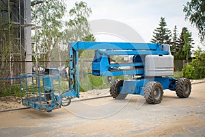 Mobile crane at construction site. Boom lift outdoors. Telescopic elevator for rent