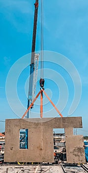 THE MOBILE CRANE LIFTING A PANEL PRECAST TO ThE SLOOF OF