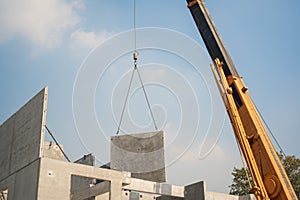 mobile crane lifting precast concrete wall panel to installation new building at Construction site