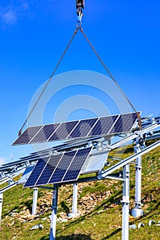 Mobile crane lifts a solar cell onto the mounting system solar construction photo