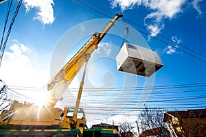 Mobile crane operating by lifting an electric generator photo