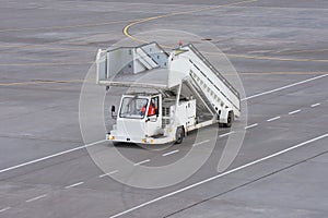 A mobile gangway with a ladder for boarding and disembarking passengers on an airplane at the airport