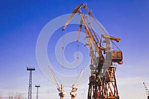 Mobile harbor cranes over blue sky. Transport and technology concept