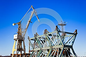 Mobile harbor cranes over blue sky. Transport and technology concept