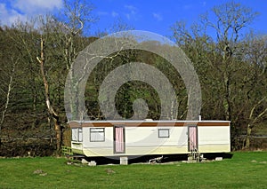 Mobile holiday home trailer home, uninhabited, closed, curtained, in sunlight.