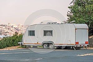 Mobile home trailer on wheels van parked in the street city park on the mountain hill view from above cityscape