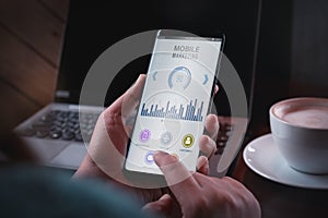 Mobile marketing and customer data analytics concept. Close up Two hand holding smart phone with Mobile Marketing appliaction.
