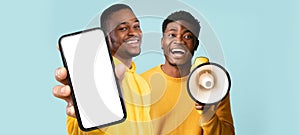 Mobile Offer. Two Black Male Demonstrating Big Blank Smartphone And Using Loudspeaker