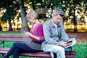 Mobile phone addiction concept - couple looking at their mobile