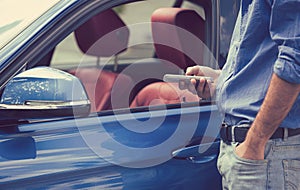 Mobile phone apps for vehicle owners. Man using smart phone to control his car