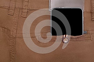 Mobile phone in back pocket of brown pants copy space