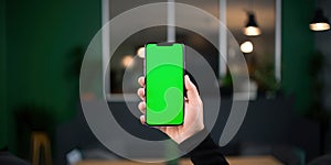 Mobile phone with blank green screen in human hand , concept of Smart technology