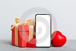 mobile phone with blank screen on colored background with hearts, calendar and gift box, valentine day concept