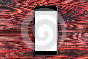 Mobile phone with blank screen mock up. isolated white screen on red wooden table background. Smartphone on wooden table. Smartpho