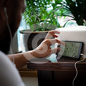 Mobile phone with blue print drawing while video call meeting at home. Bearded man work from
