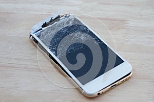 Mobile phone broken screen on wood