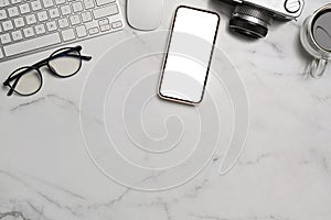 Mobile phone, camera, glasses and coffee cup on marble background.