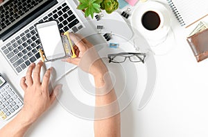 Mobile phone in cart shopping and hand man using laptop